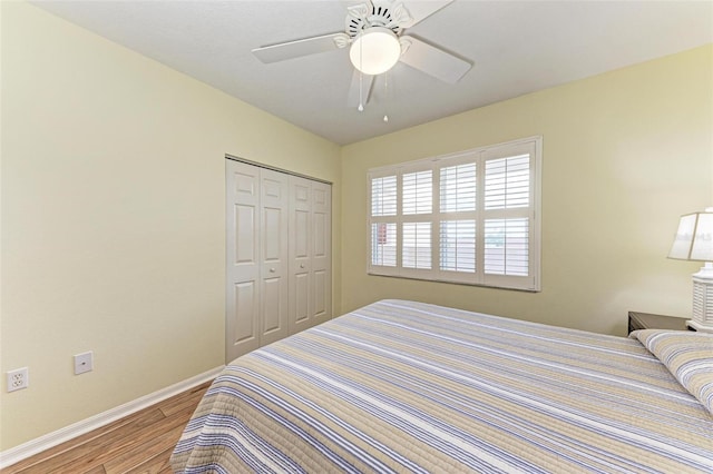 bedroom featuring baseboards, a closet, wood finished floors, and ceiling fan