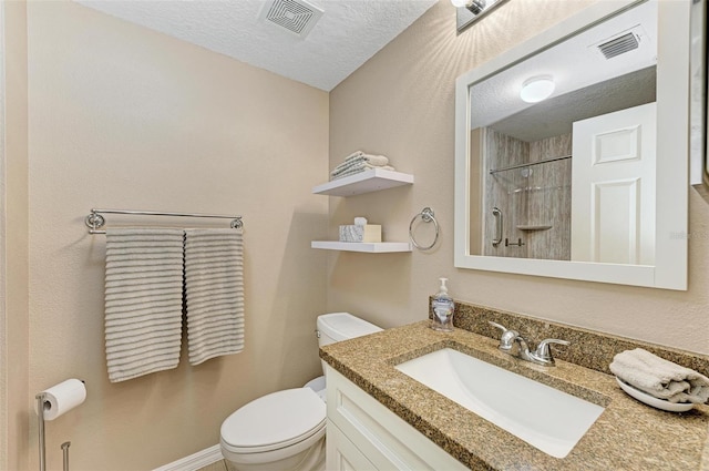 bathroom with a textured ceiling, walk in shower, vanity, and toilet