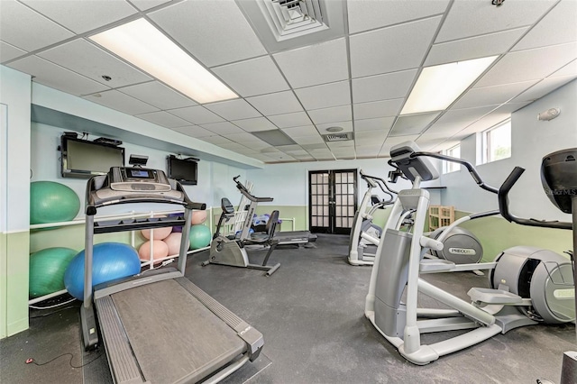 gym with french doors and a paneled ceiling