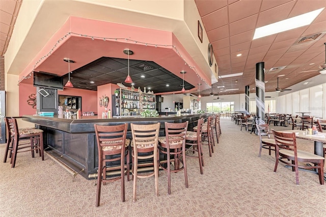 bar featuring ceiling fan, hanging light fixtures, and carpet flooring