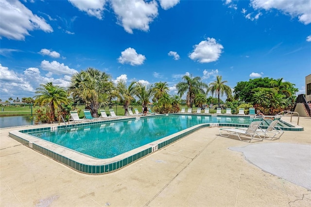 view of pool with a patio and a water view