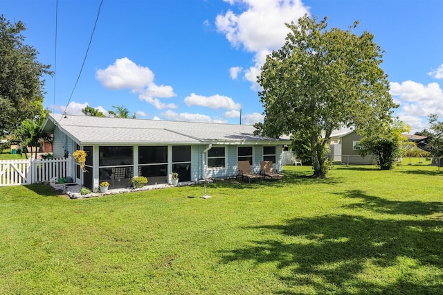 back of property with a sunroom and a yard