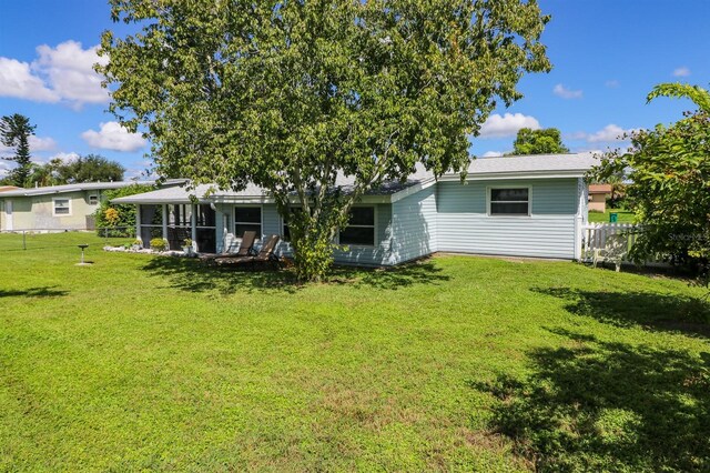 22119 Laramore Ave, Port Charlotte, FL 33952 - back of house with a sunroom, fence, and a yard