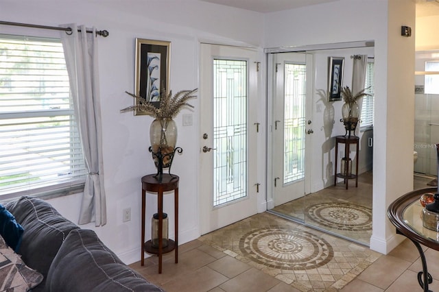 foyer entrance with light tile patterned flooring and a healthy amount of sunlight