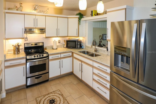 kitchen with white cabinets, sink, tasteful backsplash, decorative light fixtures, and appliances with stainless steel finishes