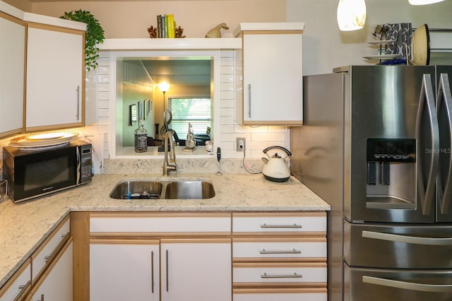 22119 Laramore Ave, Port Charlotte, FL 33952 - kitchen featuring light stone counters, backsplash, a sink, black microwave, and stainless steel refrigerator with ice dispenser