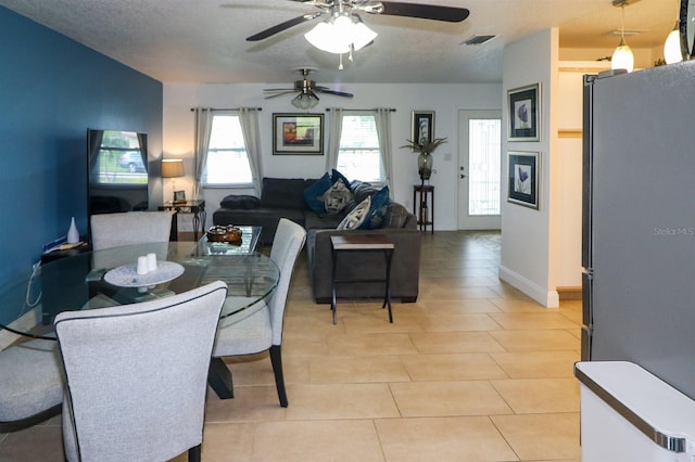 dining space featuring ceiling fan, a textured ceiling, and light tile patterned floors