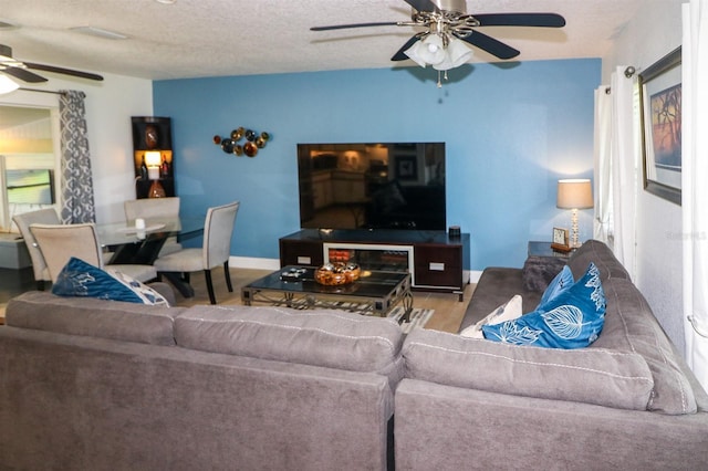 living room with ceiling fan, hardwood / wood-style floors, and a textured ceiling