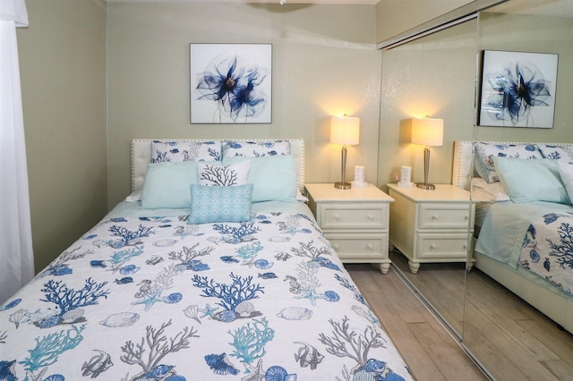 bedroom with light hardwood / wood-style flooring and a closet