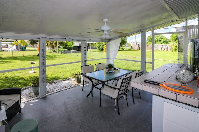 unfurnished sunroom with vaulted ceiling and ceiling fan