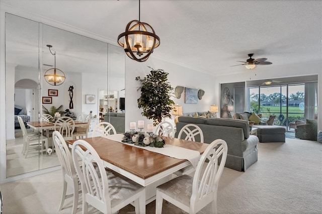 5092 Mahogany Run Ave, Sarasota, FL 34241 - dining space featuring a chandelier, ceiling fan, light carpet, crown molding, and arched walkways