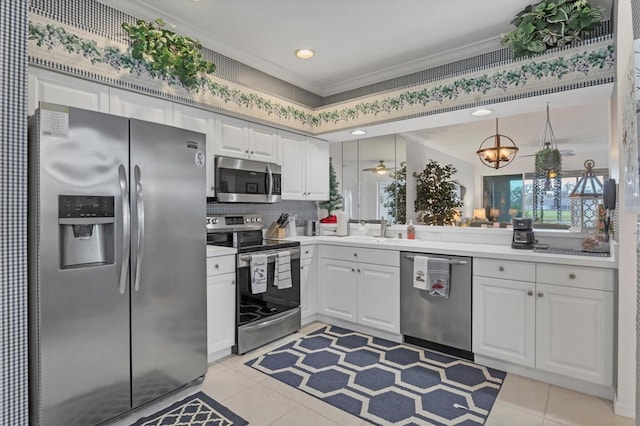 kitchen with white cabinetry, decorative light fixtures, appliances with stainless steel finishes, and ornamental molding