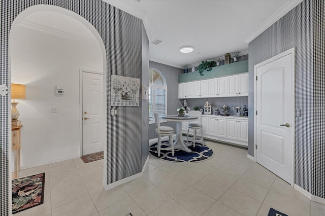 5092 Mahogany Run Ave, Sarasota, FL 34241 - kitchen featuring ornamental molding, white cabinets, light tile patterned floors, light countertops, and arched walkways
