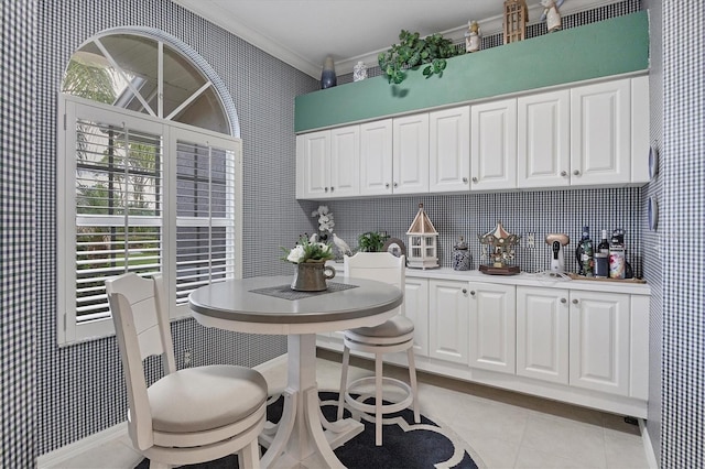 dining area featuring light tile patterned flooring and crown molding