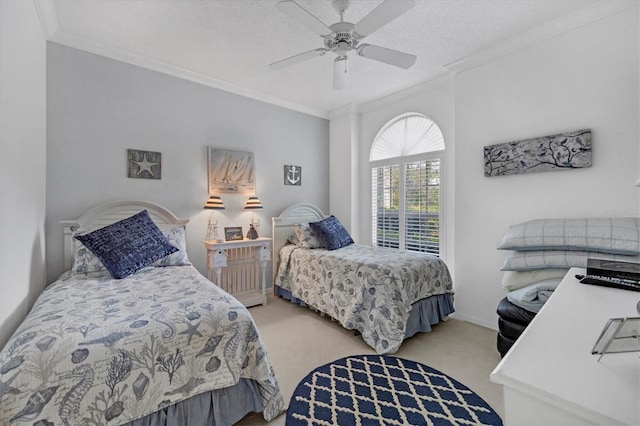 carpeted bedroom with a textured ceiling, ceiling fan, and crown molding