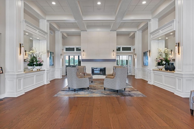 living room featuring coffered ceiling, hardwood / wood-style floors, and beam ceiling