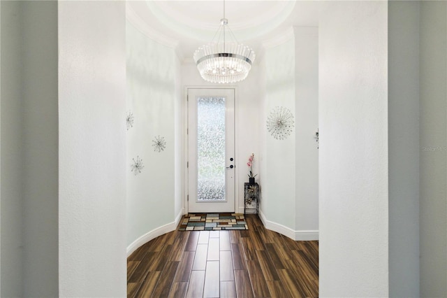 entrance foyer featuring crown molding, dark hardwood / wood-style flooring, and a chandelier