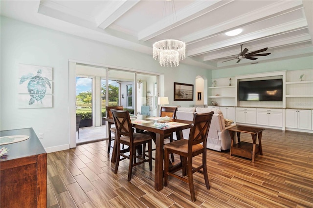 dining area featuring wood-type flooring, ornamental molding, ceiling fan with notable chandelier, and beam ceiling