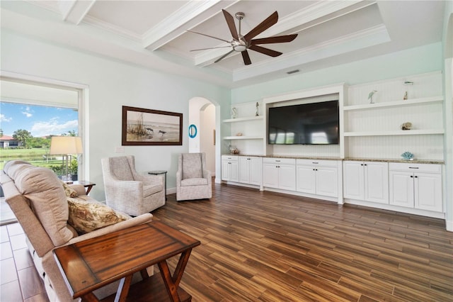 living room with ornamental molding, beam ceiling, ceiling fan, and dark wood-type flooring