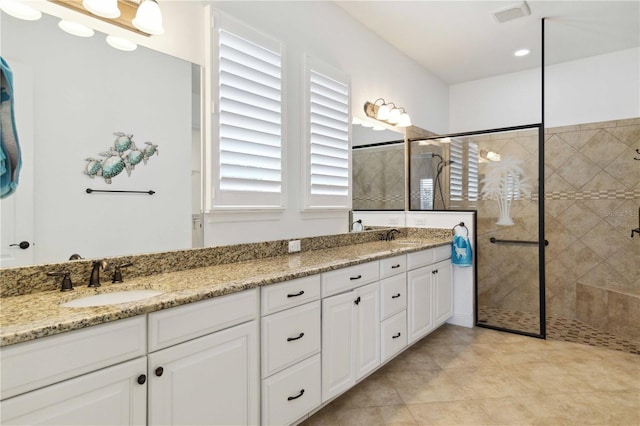 bathroom featuring vanity, tile patterned floors, and tiled shower