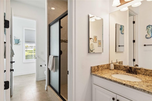 bathroom featuring vanity, toilet, and a shower with door