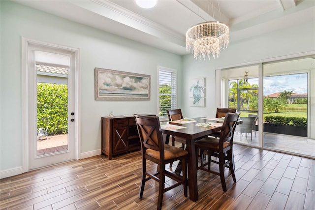 dining room featuring a healthy amount of sunlight, hardwood / wood-style floors, and a chandelier