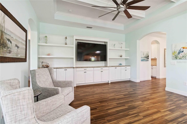 living room with ceiling fan, ornamental molding, a tray ceiling, and dark hardwood / wood-style flooring