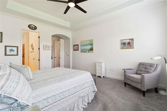 carpeted bedroom with a raised ceiling, ornamental molding, and ceiling fan