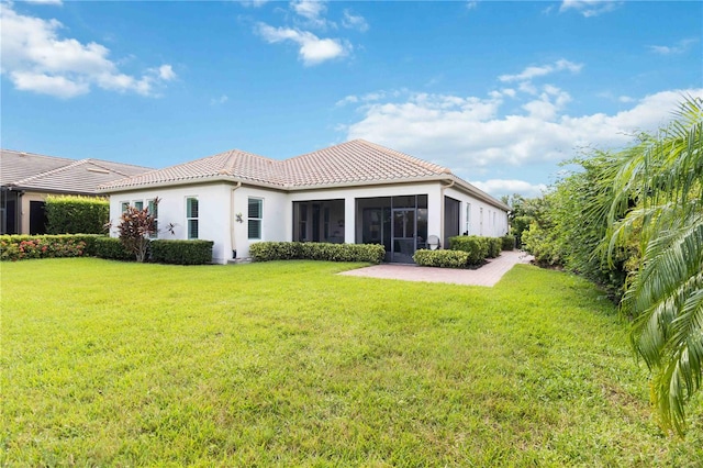 rear view of property with a lawn and a sunroom