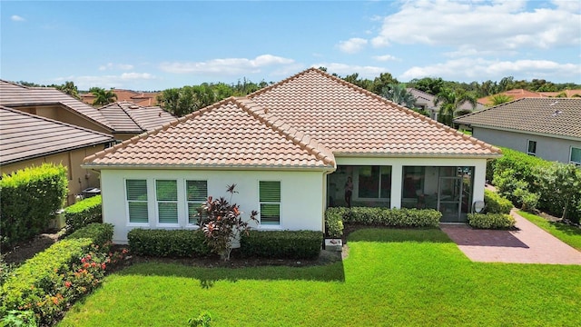 rear view of house with a sunroom and a yard