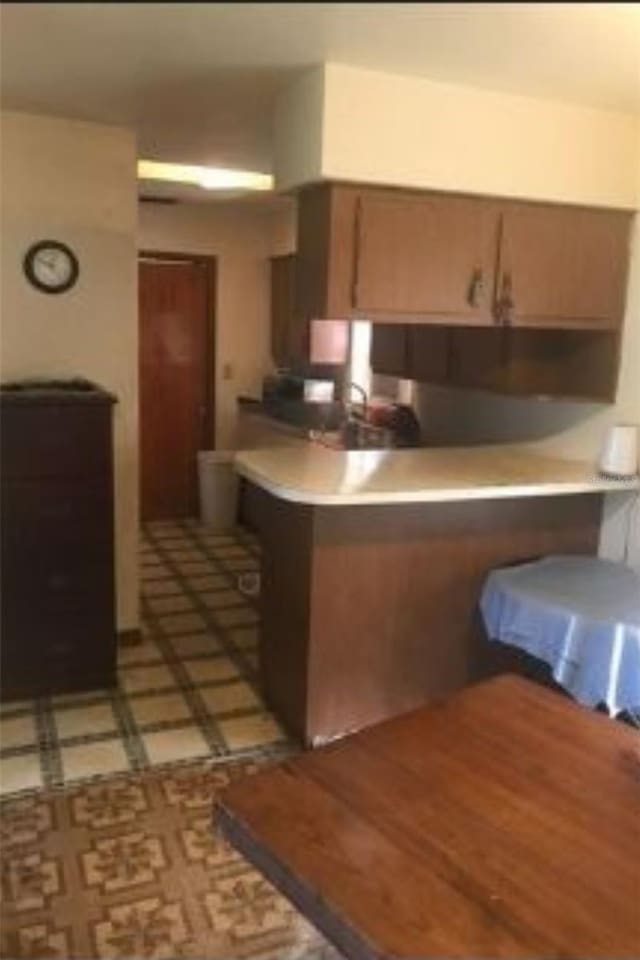 kitchen featuring dark tile patterned flooring and kitchen peninsula