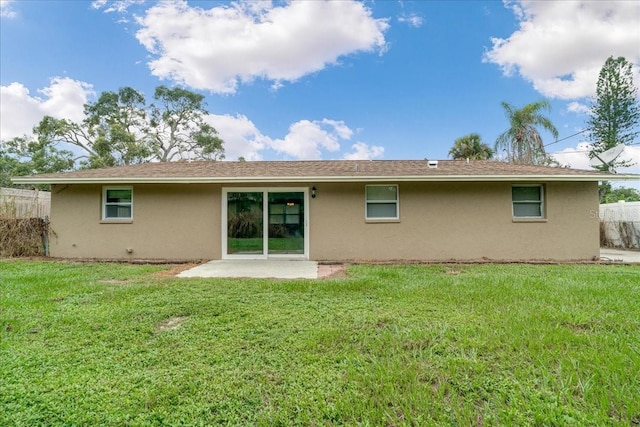 back of house featuring a lawn and a patio area