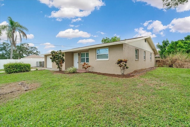 rear view of property featuring a yard and a garage