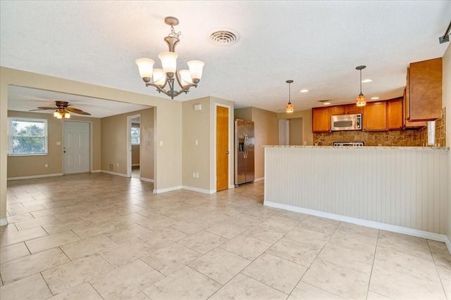 interior space with ceiling fan with notable chandelier, backsplash, pendant lighting, stainless steel appliances, and a textured ceiling