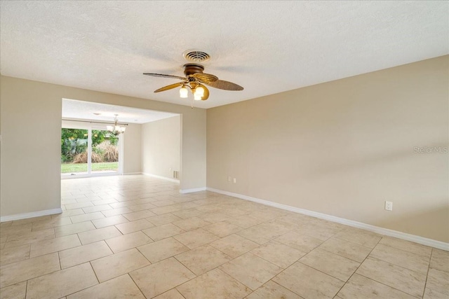 empty room featuring ceiling fan with notable chandelier, a textured ceiling, and light tile patterned flooring