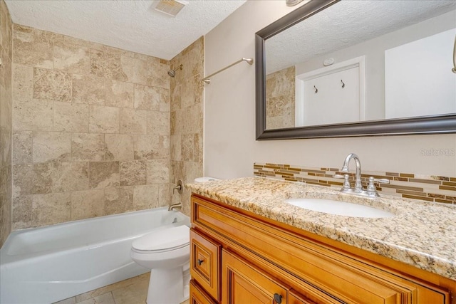 full bathroom with vanity, tiled shower / bath combo, tasteful backsplash, a textured ceiling, and toilet