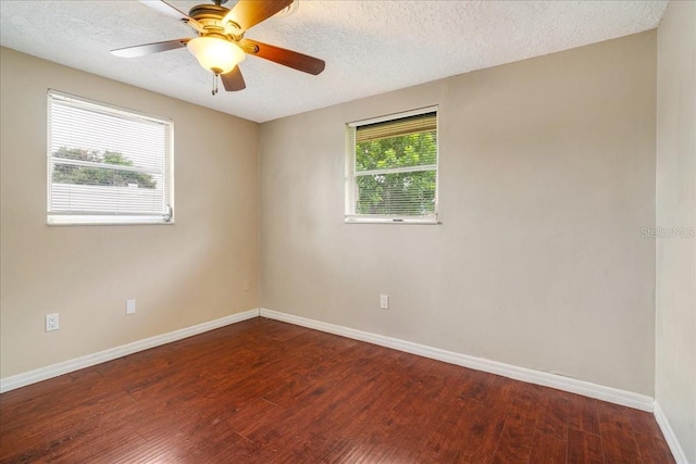 spare room featuring ceiling fan, a healthy amount of sunlight, and dark hardwood / wood-style flooring