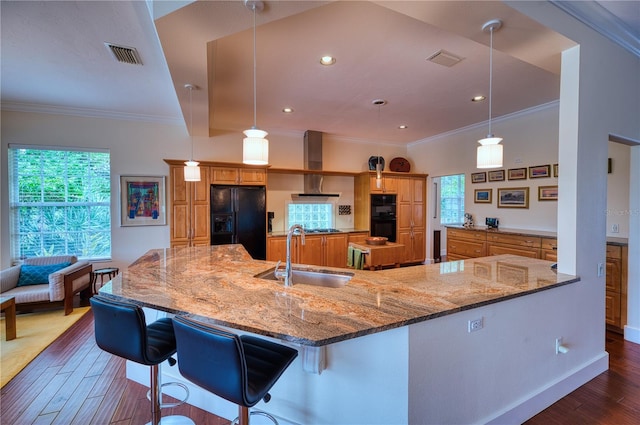 kitchen featuring decorative light fixtures, sink, a kitchen breakfast bar, and black appliances