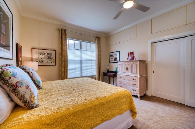 carpeted bedroom featuring ceiling fan, a closet, and crown molding