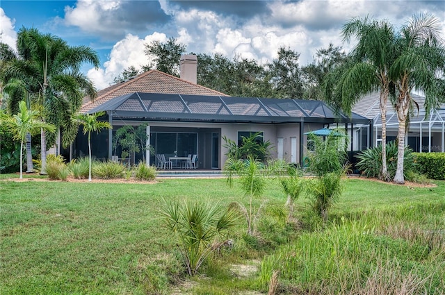 back of house with a yard and a lanai