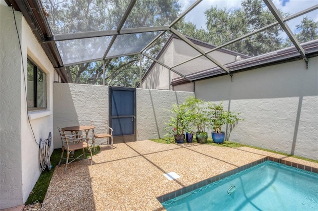 view of pool featuring glass enclosure and a patio