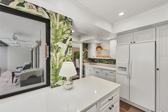 kitchen with white refrigerator with ice dispenser, white cabinetry, light countertops, open shelves, and crown molding