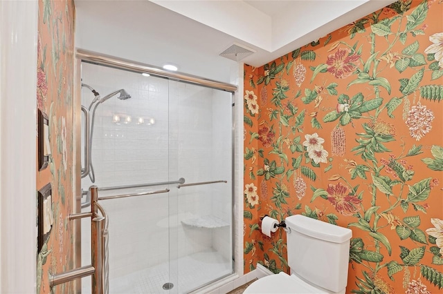 full bath featuring a stall shower, visible vents, toilet, and wallpapered walls