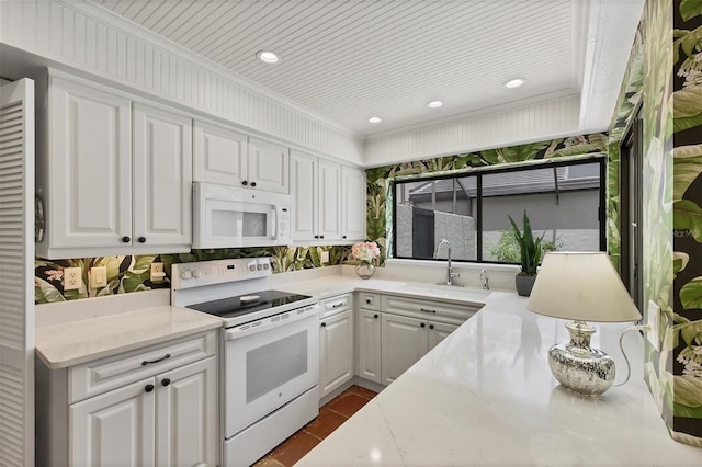 kitchen featuring white appliances, light stone countertops, white cabinetry, and crown molding