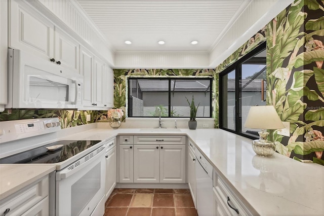 kitchen featuring white appliances, white cabinetry, a sink, and ornamental molding