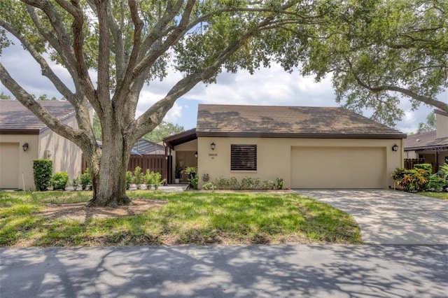 ranch-style home featuring concrete driveway, an attached garage, and stucco siding