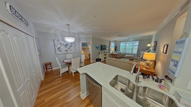 kitchen featuring stainless steel dishwasher, decorative light fixtures, light wood-type flooring, and ornamental molding