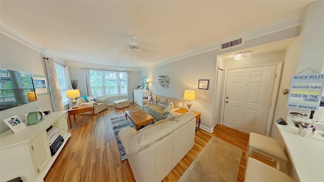 living room with light wood-type flooring, ceiling fan, and ornamental molding