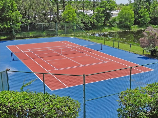 view of tennis court with a water view and basketball hoop