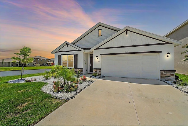 craftsman-style home featuring a garage and a lawn